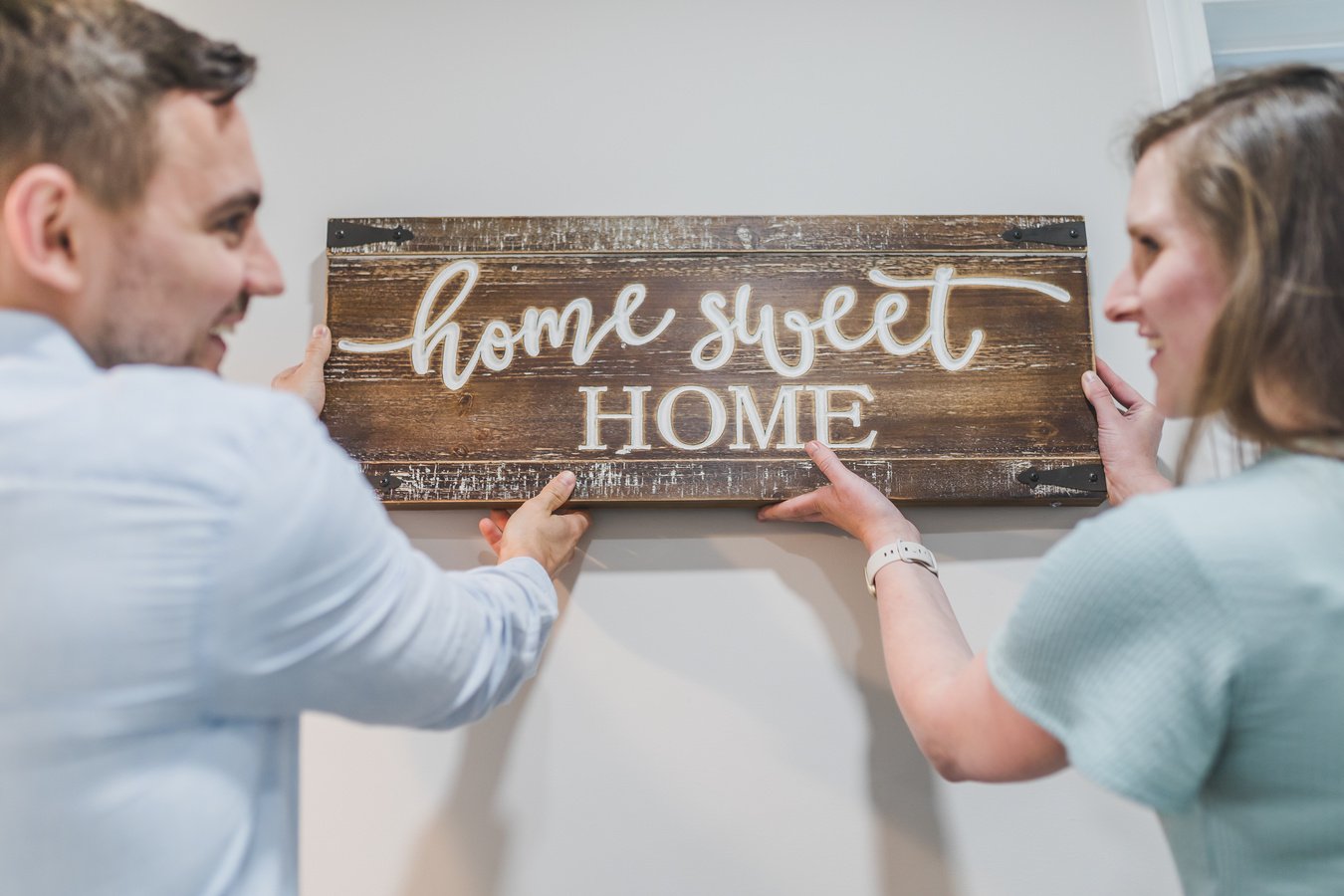 Couple Holding a Wooden Home Sweet Home Sign 